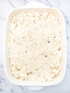 Potato mixture spread evenly in a baking dish.