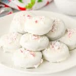 Close-up of stacked Peppermint Bark Oreos on a white plate.