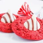 Close-up of cookies highlighting rich red color and chocolate kiss center.