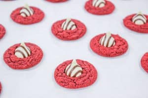 Freshly baked red velvet cookies topped with striped chocolate kisses.
