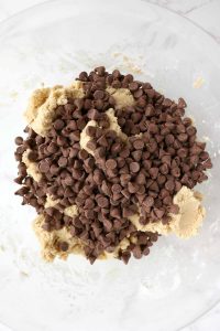 Chocolate chips poured into the cookie dough.