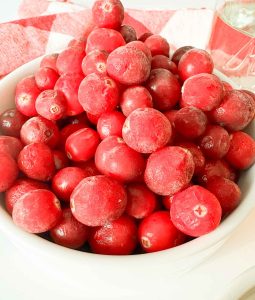 Fresh cranberries piled in a white bowl.