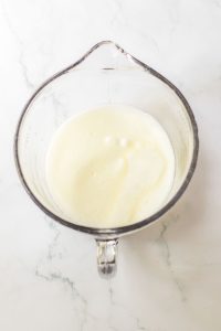 Cream whipped in a measuring cup until soft peaks form.
