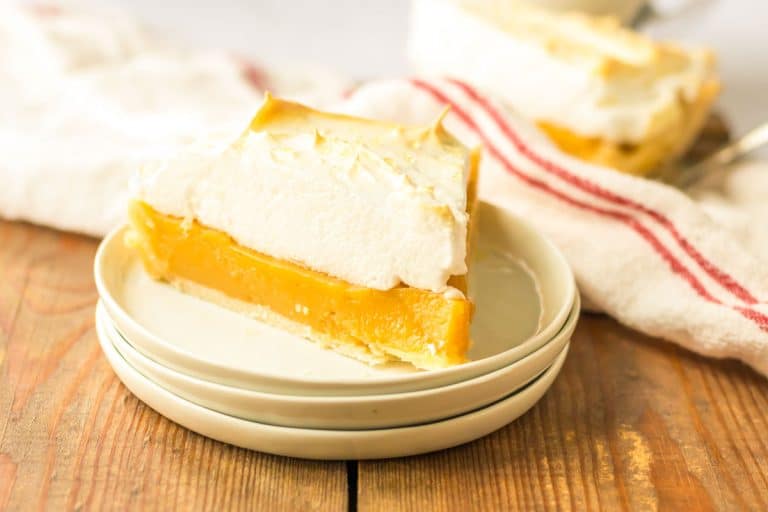 Slice of butterscotch pie with meringue on a small plate.