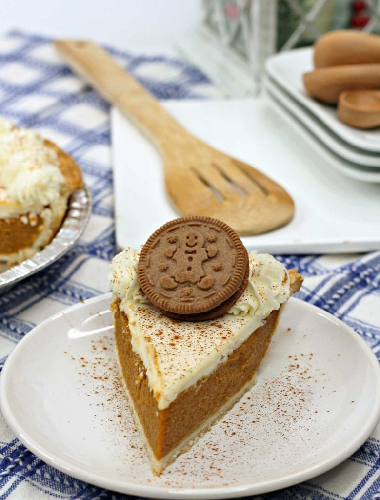 Slice of gingerbread pie topped with whipped cream and a gingerbread cookie.