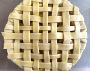 Lattice-topped apple pie brushed with egg wash before baking.