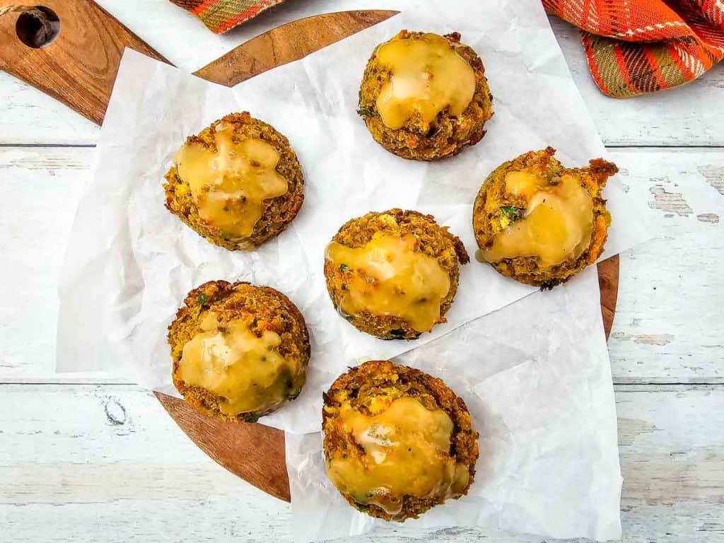 Overhead view of stuffing muffins with golden gravy topping.