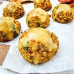 Golden stuffing muffins topped with gravy, served on parchment paper.