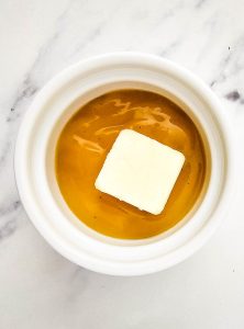 Gravy and butter in a white bowl ready to melt.