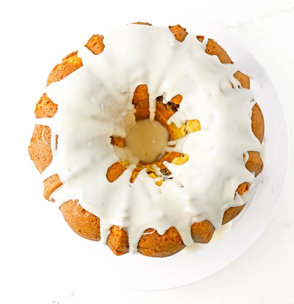Bundt cake covered in white icing dripping down the sides.