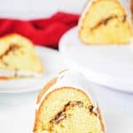 Slice of glazed cinnamon swirl Bundt cake on a white plate.