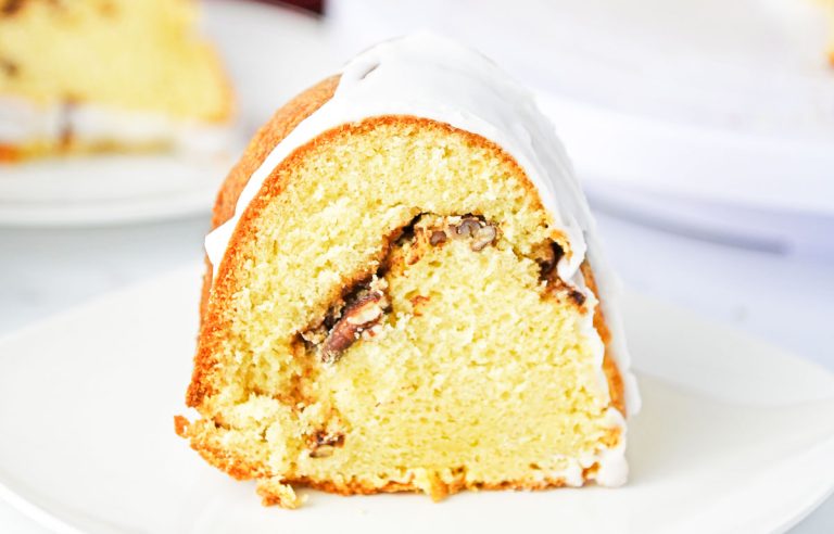 Close-up of a Bundt cake slice showing the cinnamon pecan swirl inside.