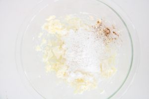 Creamed butter topped with powdered sugar and a sprinkle of cinnamon before mixing.