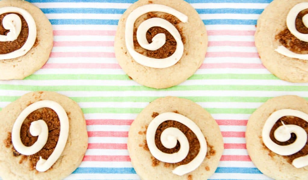 Cinnamon swirl cookies arranged in rows on a colorful striped background.