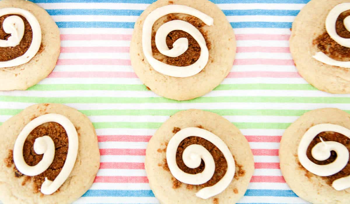 Cinnamon swirl cookies arranged in rows on a colorful striped background.