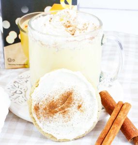 Eggnog cookies arranged on a rack and plate with cinnamon sticks scattered around.