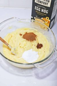 Eggnog cookie dough topped with cinnamon and dry ingredients before mixing.