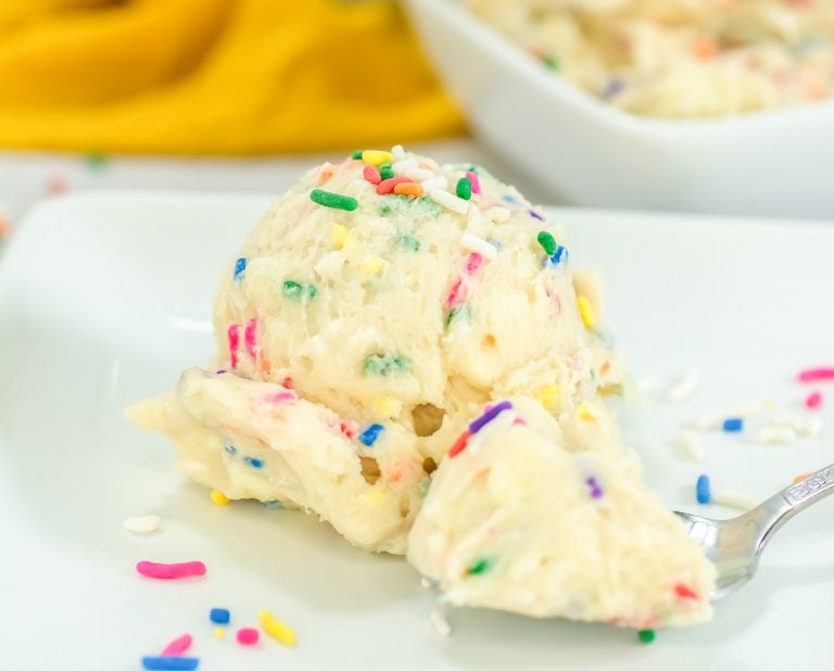 Close-up view of Funfetti edible cookie dough in a white bowl, filled with colorful sprinkles.