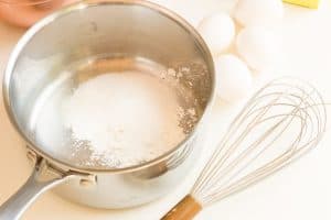 Sugar and cornstarch in a saucepan with whisk and eggs.