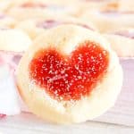 Single cookie in focus, showing jam heart center.