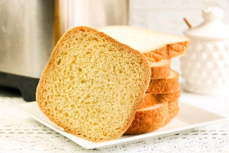Sliced white bread stacked on a white plate.