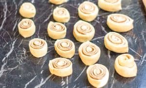 Sliced cinnamon roll pieces arranged on the work surface.