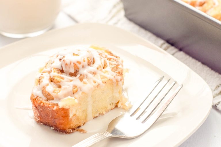 Close-up of iced cinnamon roll showing soft layers and glaze.