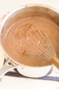 Melted chocolate pudding mixture being whisked smooth.