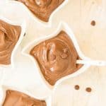 Creamy chocolate pudding served in decorative white bowls with chocolate chips.