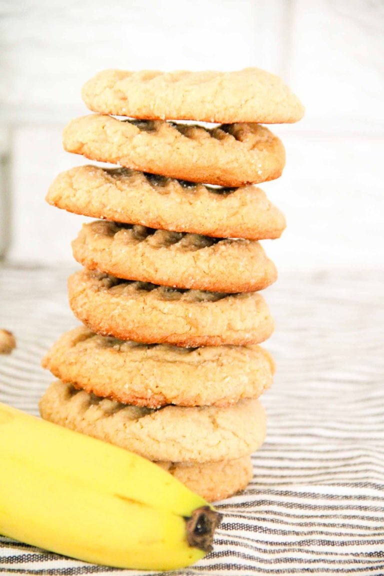 Stack of Peanut Butter Banana Cookies with bananas in the background.