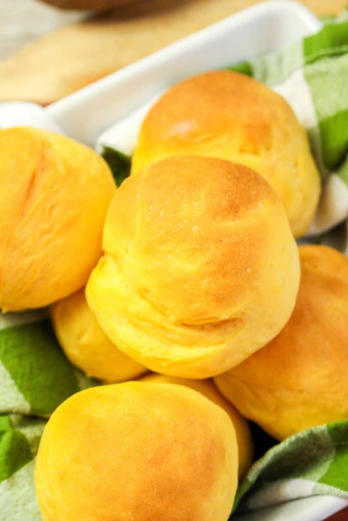 Close-up of golden brown sweet potato rolls in a basket.
