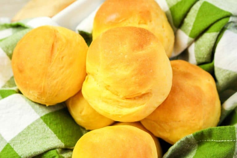 Very close view of golden brown sweet potato rolls with soft, smooth tops.