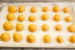 Small dough balls arranged evenly on a baking sheet before baking.